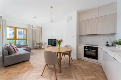 a kitchen and living room with a table and a couch at Malila Premium Apartments Cracow Rakowicka 254 in Kraków