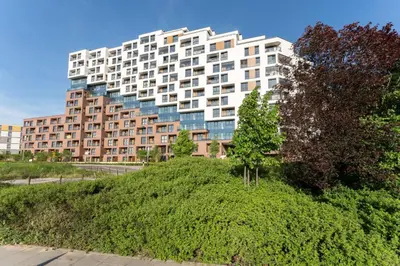 a large building on top of a green hill at Malila Premium Apartments Cracow Rakowicka 254 in Kraków