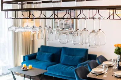 a living room with a blue couch and glasses hanging from a ceiling at Prestige Central Apartment with Sauna & Parking in Kraków