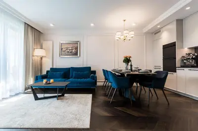 a living room with a blue couch and a table at Prestige Central Apartment with Sauna & Parking in Kraków