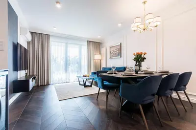 a dining room with a table and blue chairs at Prestige Central Apartment with Sauna & Parking in Kraków