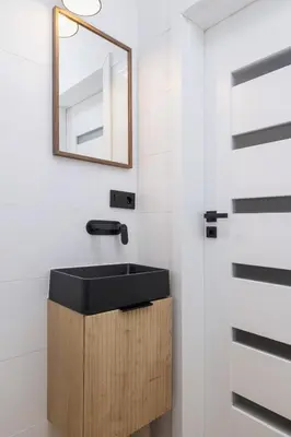 a bathroom with a black sink and a mirror at Apartment with Balcony - Łobzowska 57 street in Kraków