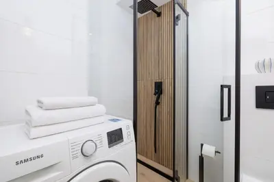 a washing machine in a bathroom with a mirror at Apartment with Balcony - Łobzowska 57 street in Kraków