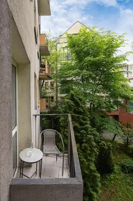 a balcony with a table and a chair on a building at Apartment with Balcony - Łobzowska 57 street in Kraków