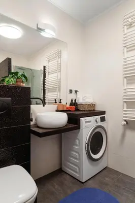 a bathroom with a washing machine and a sink at OSKA Apartment near Expo, Tauron Arena in Kraków