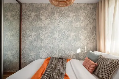 a room with a couch and a wall with wallpaper at OSKA Apartment near Expo, Tauron Arena in Kraków