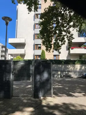 a fence in front of a tall building at OSKA Apartment near Expo, Tauron Arena in Kraków