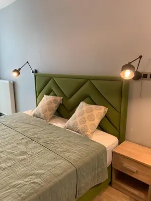 a bedroom with a green bed with two pillows at Rajska 3 in Kraków