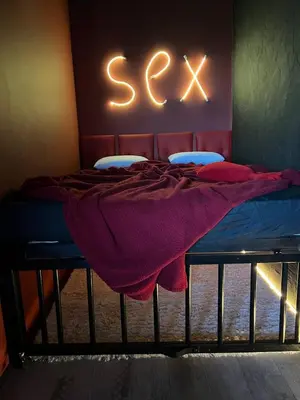 a bedroom with a bed with a green and white wall at Lust&Desire BDSM Krakow Apartment in Kraków