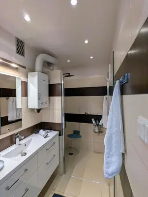 a white bathroom with a sink and a shower at Apartament na Kazimierzu in Kraków