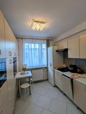 a kitchen with white appliances and a table and a window at Apartament na Kazimierzu in Kraków