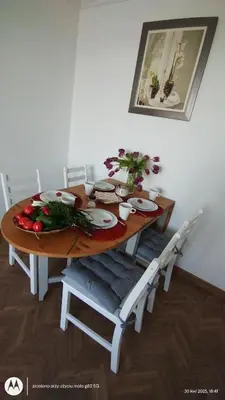 a wooden table with white chairs and a dining room at Apartament na Kazimierzu in Kraków