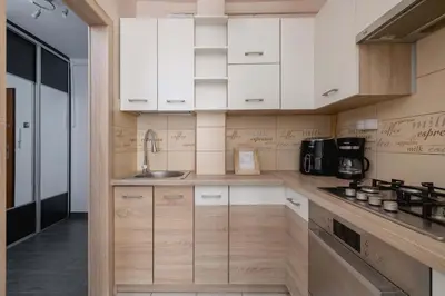 a kitchen with white cabinets and a sink at Okólna Cozy Apartment Remote Work by Noclegi Renters in Kraków