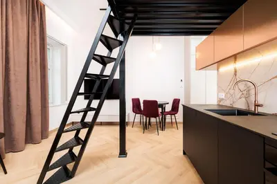 a loft bed with a ladder in a kitchen at City of the Kings - Riverside K22 M13&28 in Kraków
