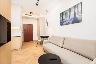 a living room with a white couch and a table at City of the Kings - Riverside K22 M13&28 in Kraków