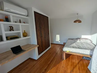 a room with a bed and a wooden door at Modernistyczna willa poety i aktorki, z widokiem na jezioro i góry oraz prywatnym basenem, sauną, kominkiem, lasem i ogrodem in Rożnów