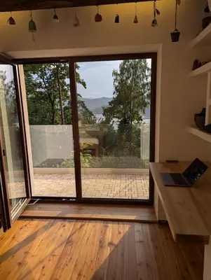 a room with a large sliding glass door with a view at Modernistyczna willa poety i aktorki, z widokiem na jezioro i góry oraz prywatnym basenem, sauną, kominkiem, lasem i ogrodem in Rożnów
