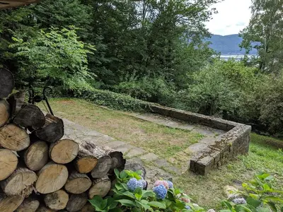 a garden with a pile of logs and flowers at Modernistyczna willa poety i aktorki, z widokiem na jezioro i góry oraz prywatnym basenem, sauną, kominkiem, lasem i ogrodem in Rożnów