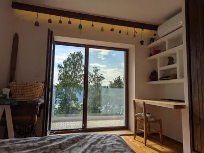 a bedroom with a large sliding glass door with a window at Modernistyczna willa poety i aktorki, z widokiem na jezioro i góry oraz prywatnym basenem, sauną, kominkiem, lasem i ogrodem in Rożnów
