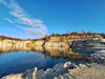 a river with a building on the side of a cliff at Krakowskie Malediwy in Kraków