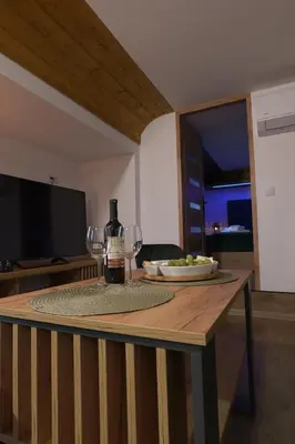 a table with wine glasses and a plate of food at Magiczny Widok Tiny House in Jurków
