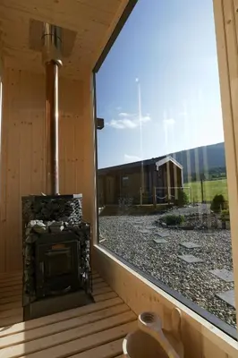 a screened in porch with a fireplace and a window at Magiczny Widok Tiny House in Jurków