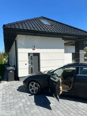 a black car parked in front of a garage at Villa Kraków 2 in Kraków