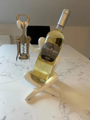 a bottle of wine on a stand on a table at Villa Kraków 2 in Kraków