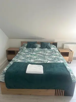 a bedroom with a large bed with a green comforter at Villa Kraków 2 in Kraków