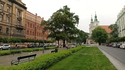 a street with benches in a city with buildings at KING JAGIELLO Apartment in Kraków