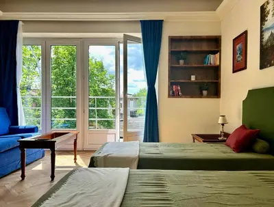 a bedroom with two beds and a large window at Dom Parkowy in Kraków