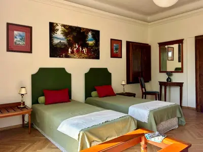 two beds in a room with a painting on the wall at Dom Parkowy in Kraków