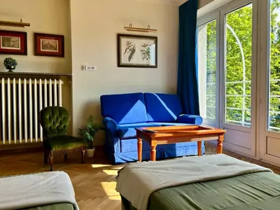 a living room with a blue couch and a table at Dom Parkowy in Kraków