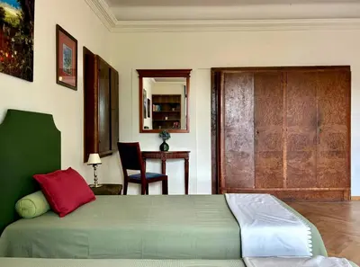 a bedroom with a green bed with a red pillow at Dom Parkowy in Kraków