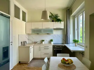 a kitchen with a table with a bowl of fruit on it at Dom Parkowy in Kraków