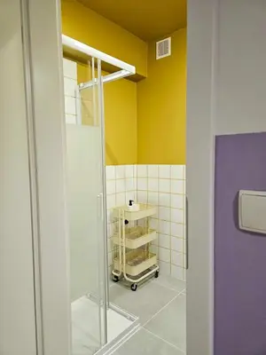 a bathroom with a shower and yellow walls at Lovely Sparkly Apartment in Kraków