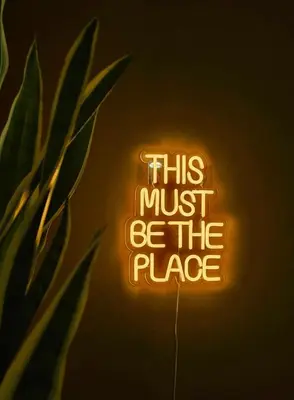 a neon sign that says this must be the place at Lovely Sparkly Apartment in Kraków