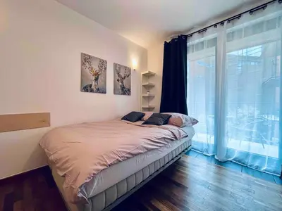a bedroom with a bed and a large window at Central Apart Railway Station in Kraków