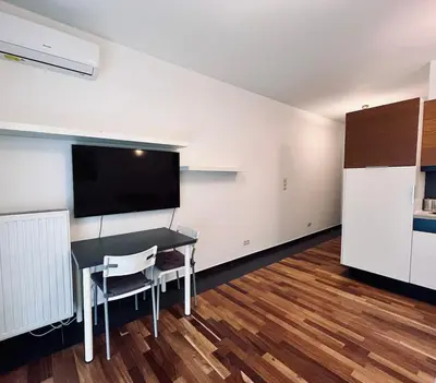 a room with a desk and a tv and a table and chairs at Central Apart Railway Station in Kraków