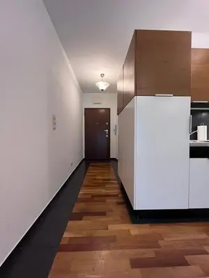 a kitchen with a white refrigerator and a wooden floor at Central Apart Railway Station in Kraków
