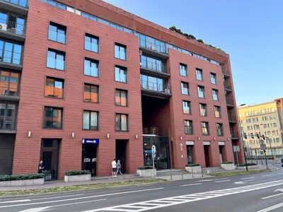 a red brick building on the side of a street at Central Apart Railway Station in Kraków