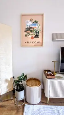a living room with a table and a picture on the wall at Kaszmir Sky Apartment by Vistula River in Kraków