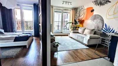 a living room with a couch and a bedroom at Kaszmir Sky Apartment by Vistula River in Kraków