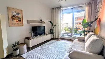 a living room with a couch and a flat screen tv at Kaszmir Sky Apartment by Vistula River in Kraków