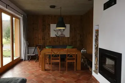 a dining room with a wooden table and chairs at Willa Potoczówka in Rzyki
