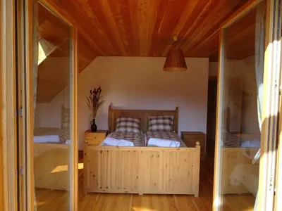 a bedroom with a wooden bed in a room at Willa Potoczówka in Rzyki