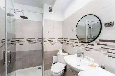 a bathroom with a sink toilet and a mirror at Konecznego Urban Escape Studio by BookingHost in Kraków