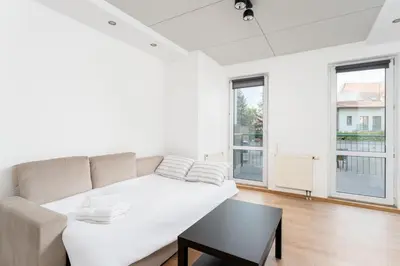 a white living room with a couch and a table at Konecznego Urban Escape Studio by BookingHost in Kraków