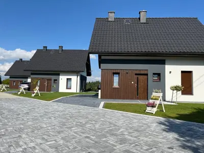a house with a brick driveway in front of it at Agroturystyka Nad Lasem - Domki w górach in Toporzysko