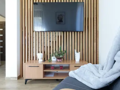 a living room with a tv and a wooden table at Agroturystyka Nad Lasem - Domki w górach in Toporzysko